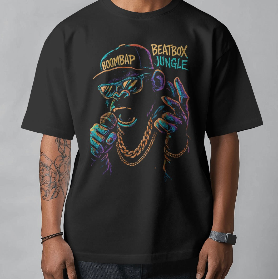 Black t-shirt with colorful graphic design of a person wearing a cap and sunglasses, text 'BOOMBAP' and 'BEATBOX JUNGLE'.
