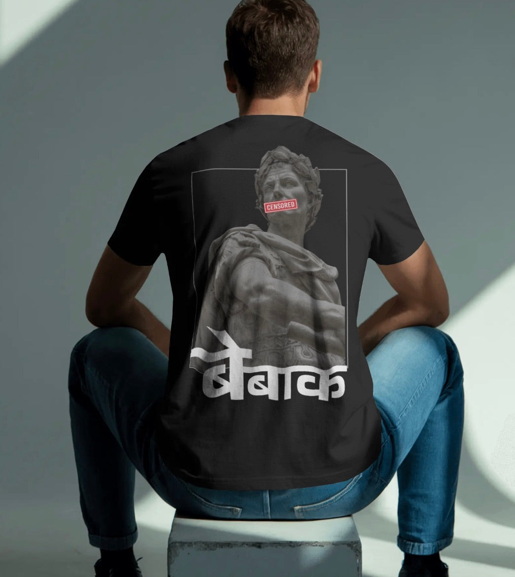 Person wearing a black t-shirt with a statue graphic and text on the back, sitting against a gray background.