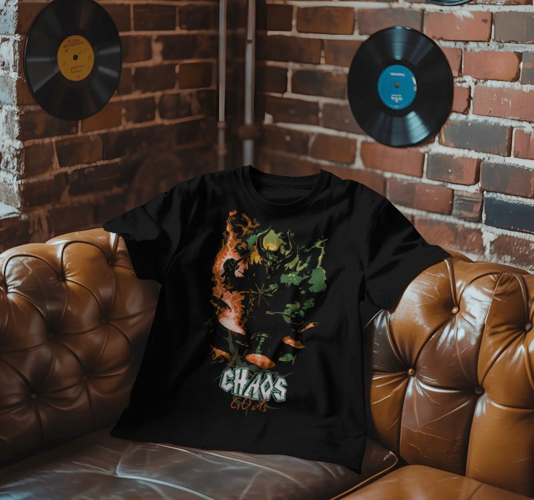 Black t-shirt with graphic design and 'CHAOS GODS' text on a brown leather couch against a brick wall with records.