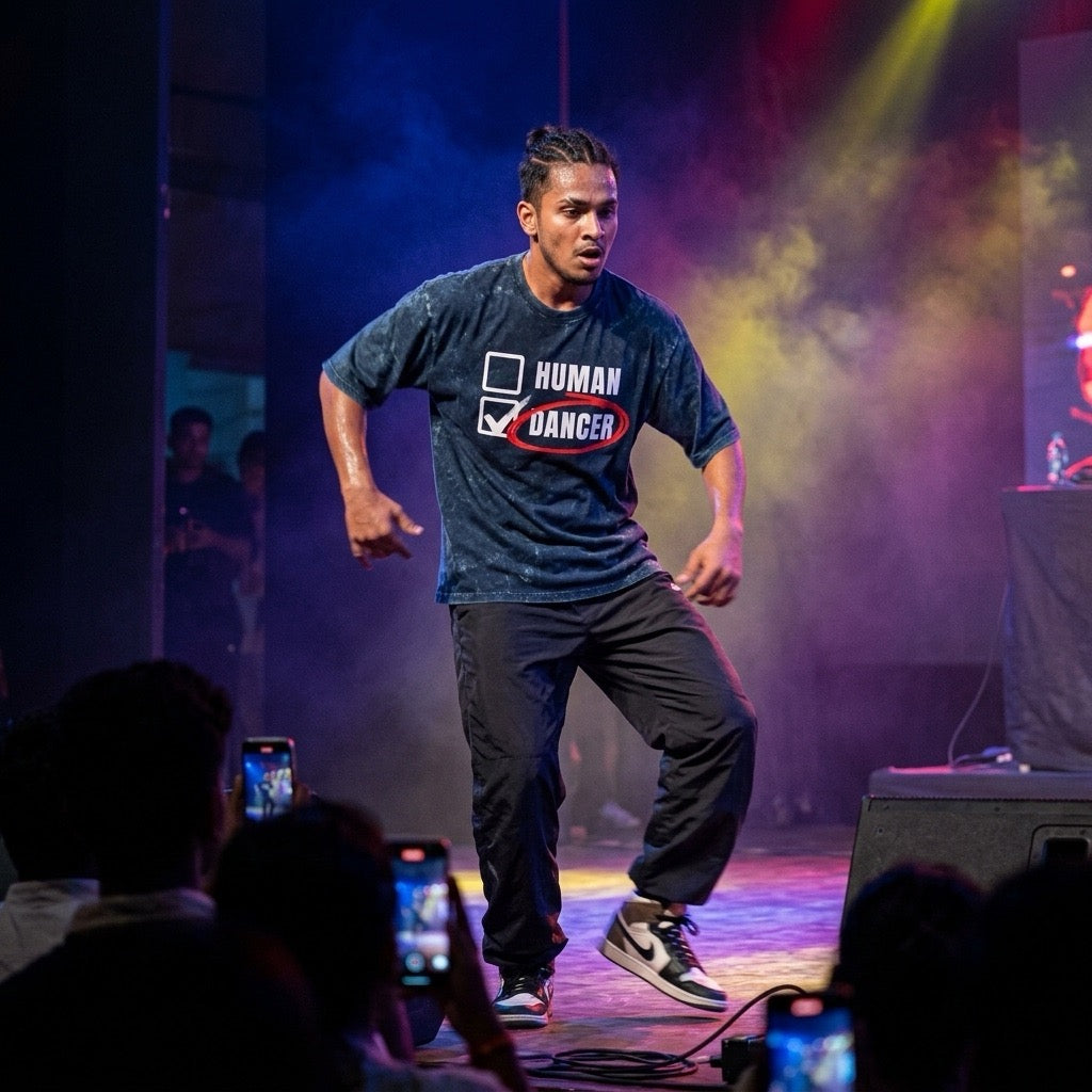Dancer performing on stage wearing DrummerKong T-shirt with colorful lights and audience in the foreground