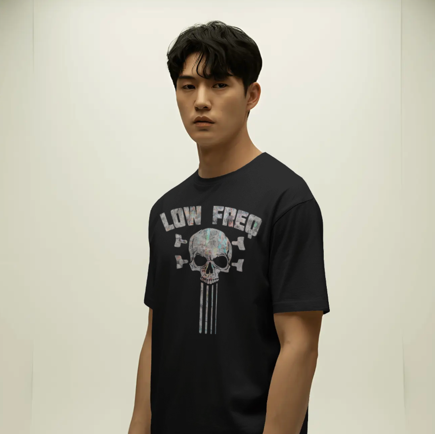 Person wearing a black t-shirt with a graphic design on a plain background