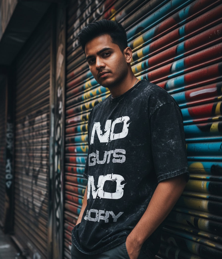 Person wearing a black t-shirt with text, standing against a colorful shutter.
