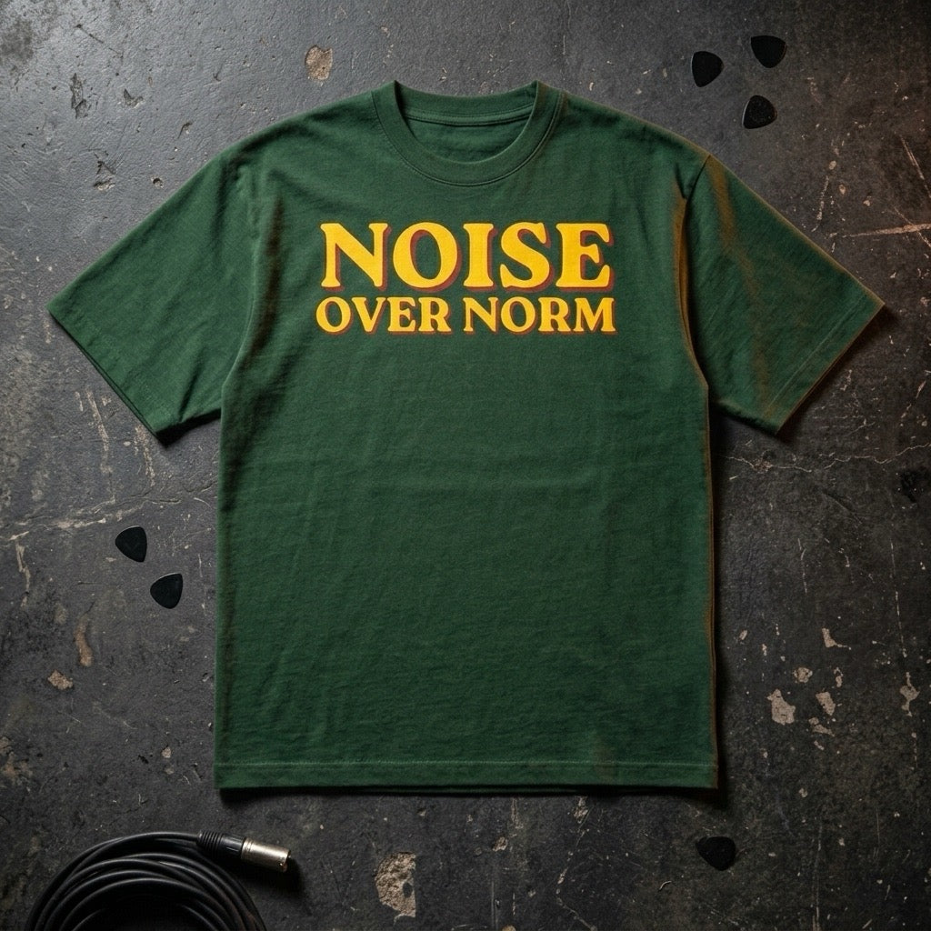 Green t-shirt with 'NOISE OVER NORM' text on a textured dark surface