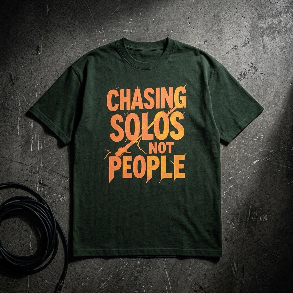 Green Drummerkong t-shirt with orange text 'CHASING SOLOS NOT PEOPLE' on a textured dark background