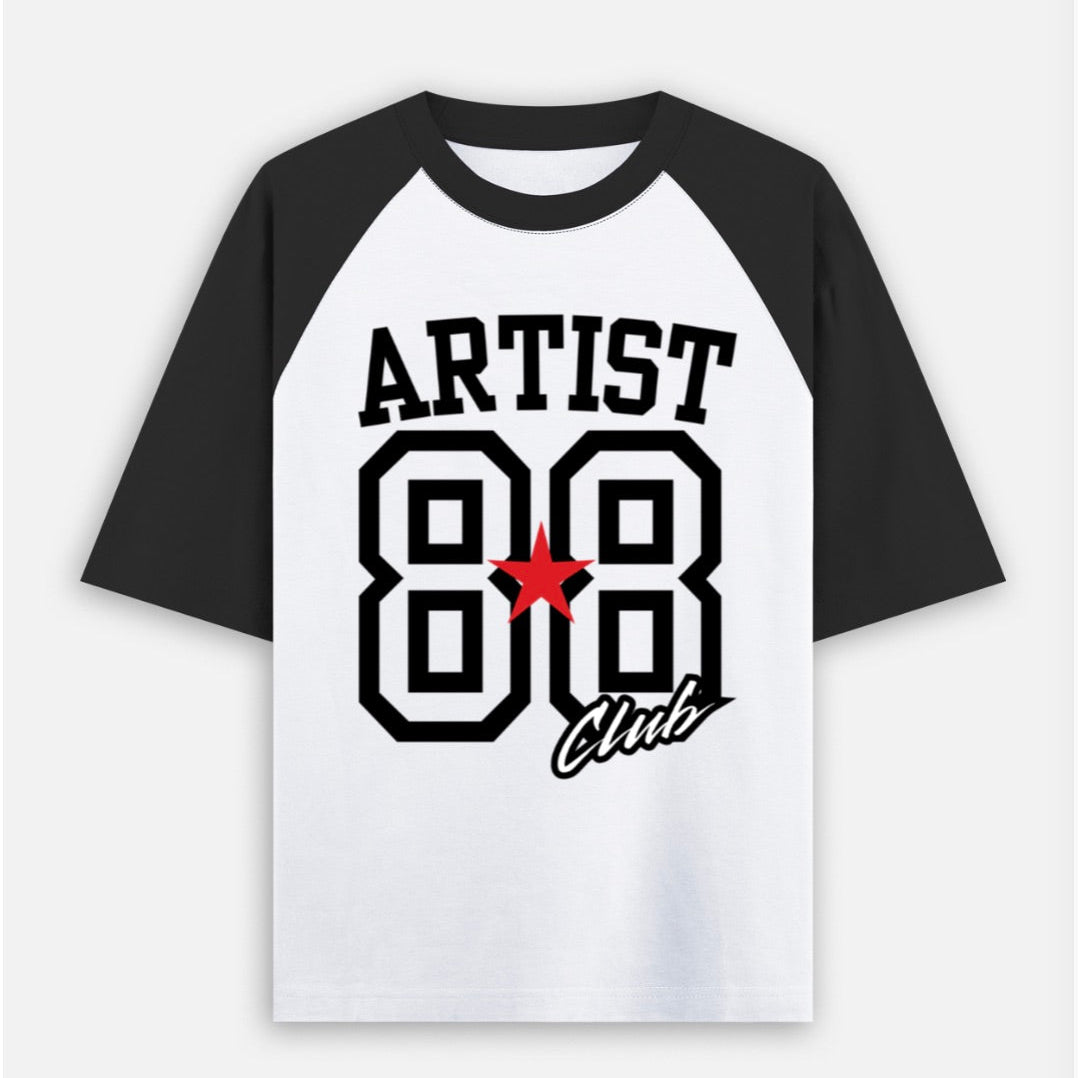 A raglan-style baseball t-shirt with a white body and black sleeves, featuring a graphic print on the front with the text 'ARTIST 88 Club' and a red star accent.