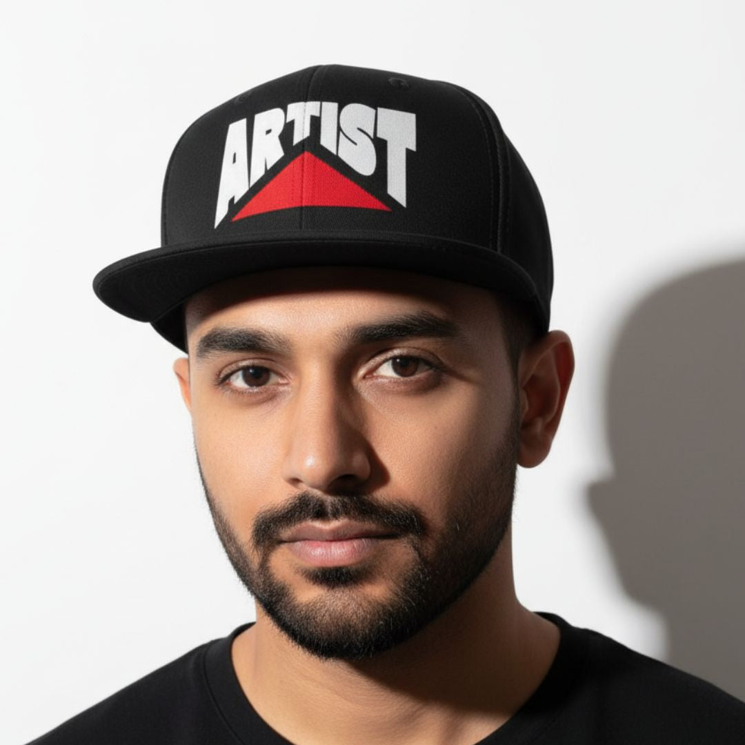 Artist wearing Drummerkong merchandise black cap with 'ARTIST' printed on it against a white background