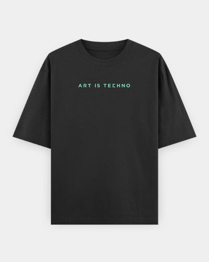 A black oversized short-sleeve crewneck t-shirt with the text 'ART IS TECHNO' printed in a light mint green sans-serif font across the chest, displayed on a clean light gray background.