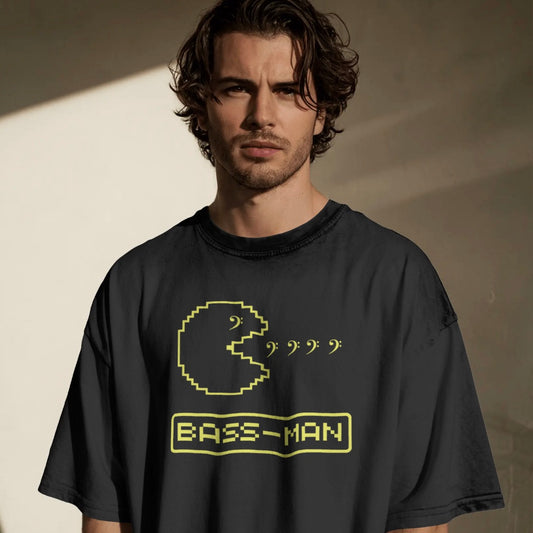 Man wearing a black t-shirt with a yellow graphic and Bass Man text against a neutral background
