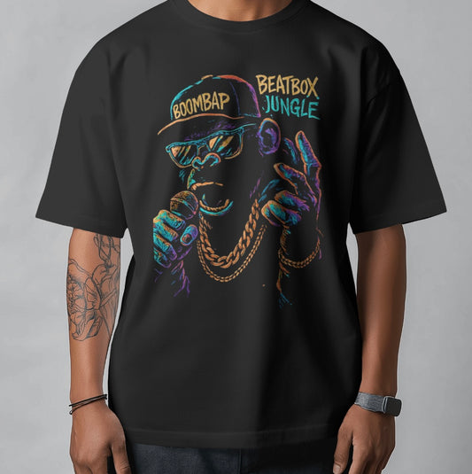 Black t-shirt with colorful graphic design of a person wearing a cap and sunglasses, text 'BOOMBAP' and 'BEATBOX JUNGLE'.