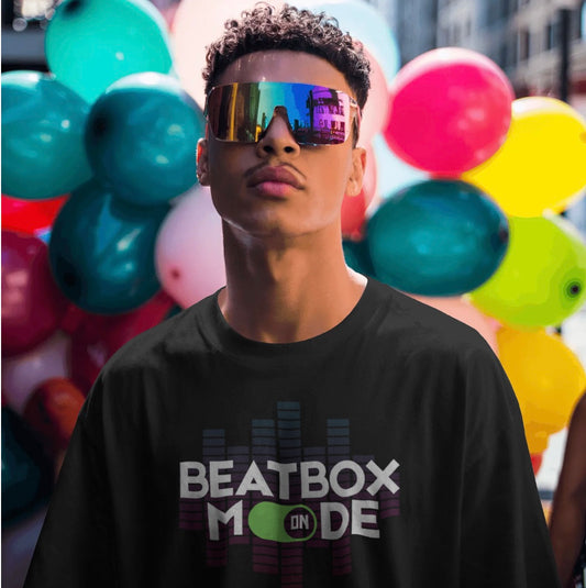 Person wearing a black t-shirt with 'Beatbox Mode' text in front of colorful balloons