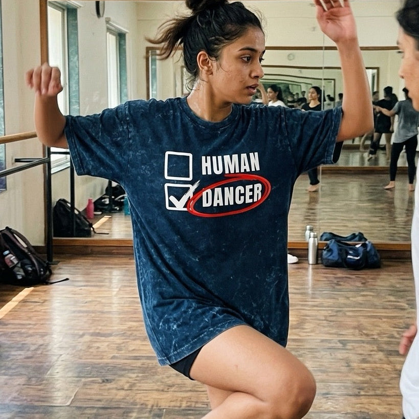 girl in a dance studio wearing a 'Human Dancer' t-shirt, performing a dance move.