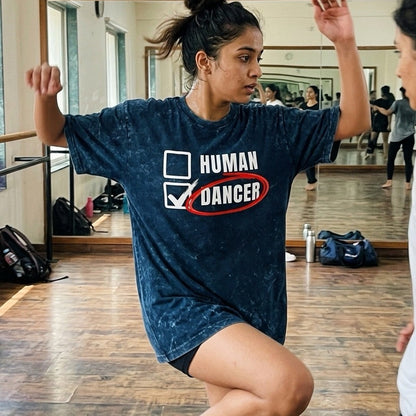 girl in a dance studio wearing a 'Human Dancer' t-shirt, performing a dance move.