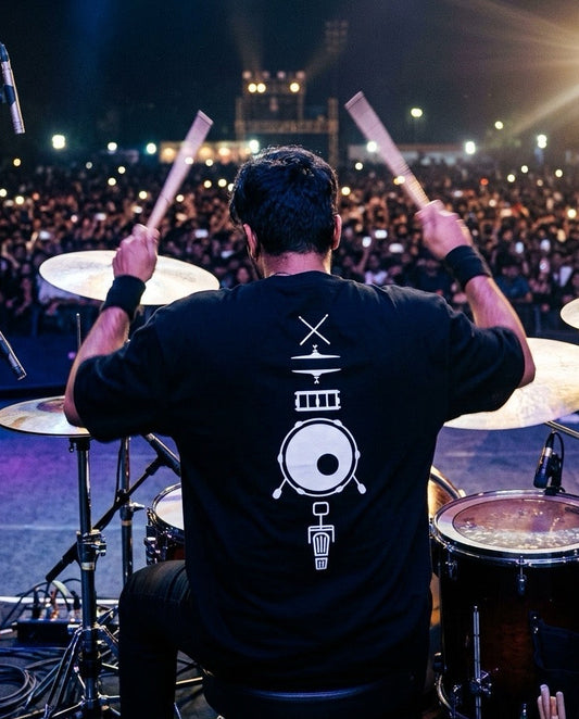 Drummer performing on stage with a large audience in the background