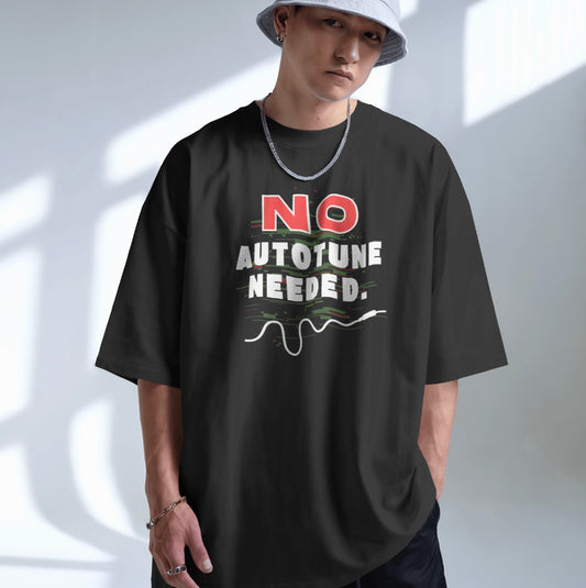 Person wearing a black t-shirt with 'NO AUTOTUNE NEEDED' text on a plain background
