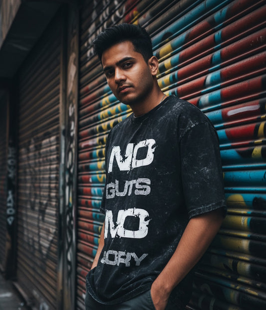 Person wearing a black t-shirt with text, standing against a colorful shutter.