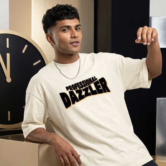 An artist wearing a cream-colored t-shirt with 'PROFESSIONAL DAZZLER' printed in black and gold across the chest, posing in front of modern geometric display blocks.