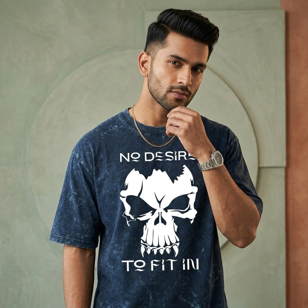 Man wearing a blue t-shirt with a skull design and text, standing against a neutral wall.