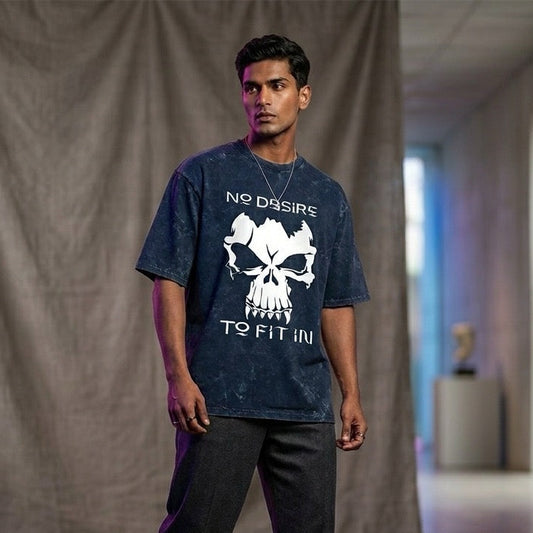 Person wearing a dark t-shirt with a skull design and text, standing in a room with a neutral background.