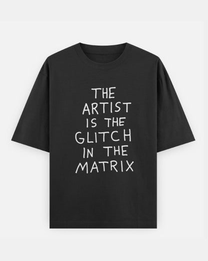 Drummerkong Merchandise Black t-shirt with text "artist is the glitch in the matrix" on a light gray background