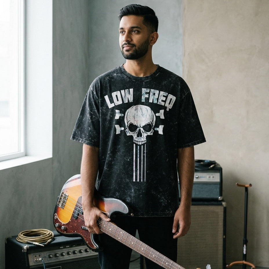 Man holding a bass guitar in a room with musical equipment