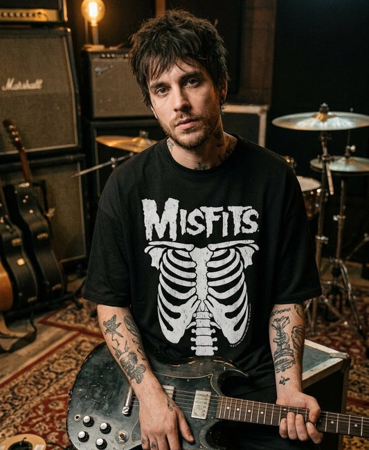 Person wearing a Misfits t-shirt holding a guitar in a music studio setting